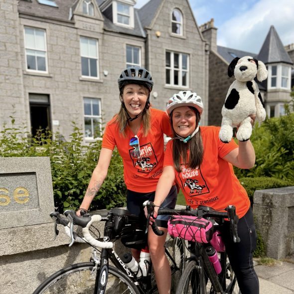 Paris Cycling Duo Sarah and Katy lift their bikes in celebration at the Eiffel Tower 2