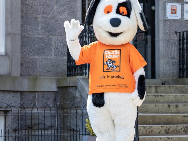 Charlie Dog waving at front door